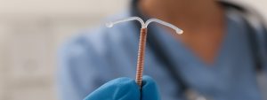 IUD close up, with doctor in the background